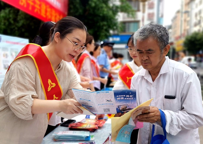 东兰营管部向群众介绍外汇政策法规.jpg